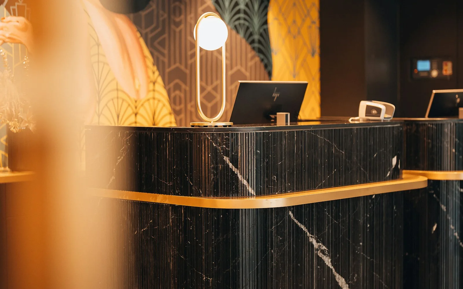 Recepcja hotelowa z ciemnego marmuru ze złotym wykończeniem w lobby hotelu