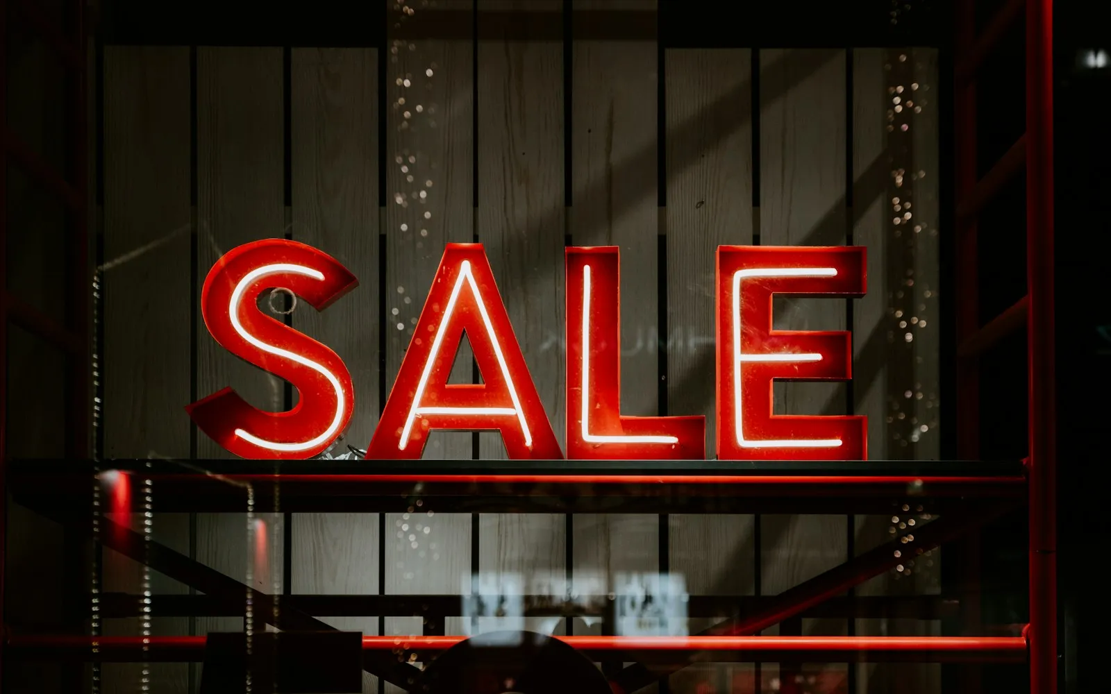 Czerwony neon z napisem SALE w ciemnej witrynie sklepu
