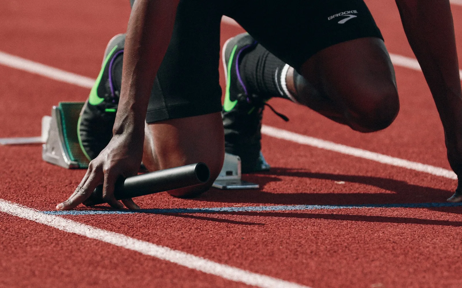 Sprinter w blokach startowych na czerwonej bieżni lekkoatletycznej