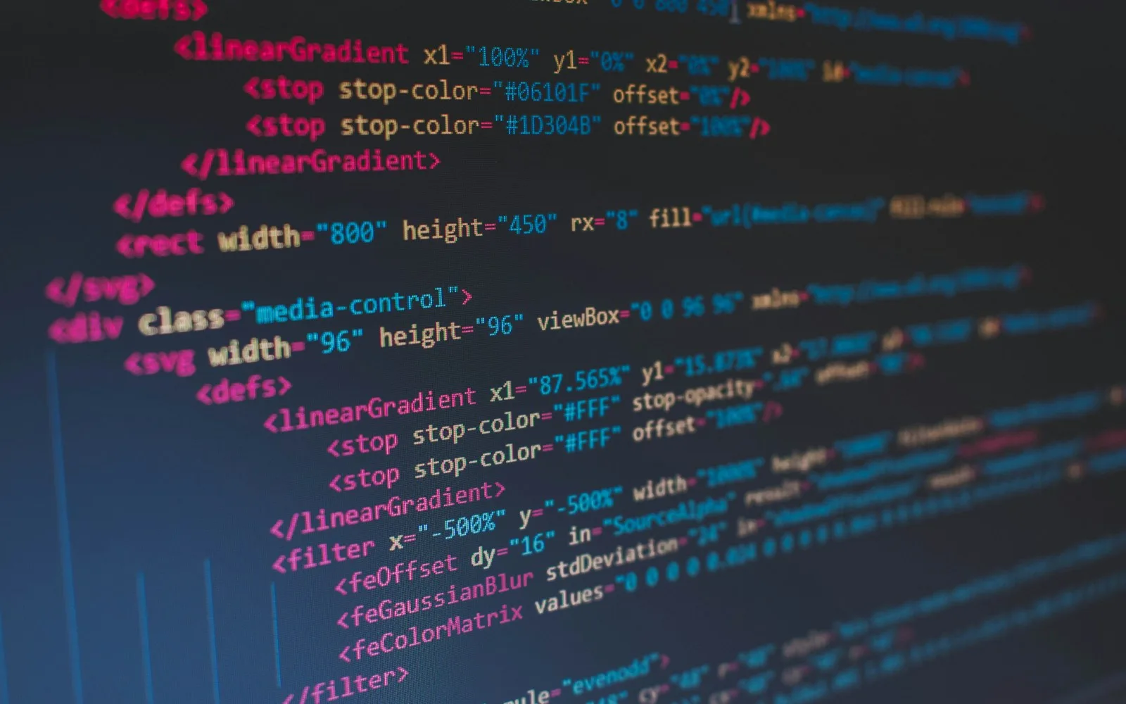 Kolorowe linie kodu HTML i CSS w edytorze na ciemnym tle